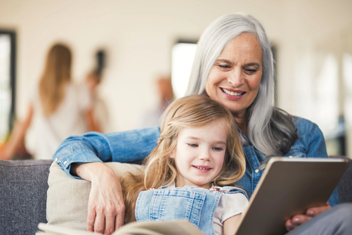 Senior with grandkid watching movie on tablet