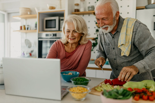 Senior couple streaming cooking show in kitchen